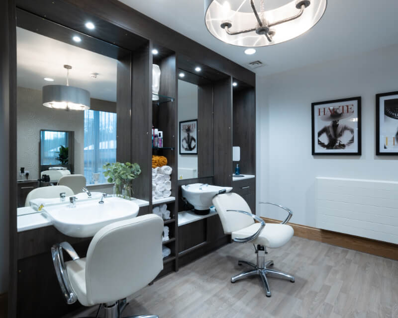 Salon with a chair and a sink to wash hair.