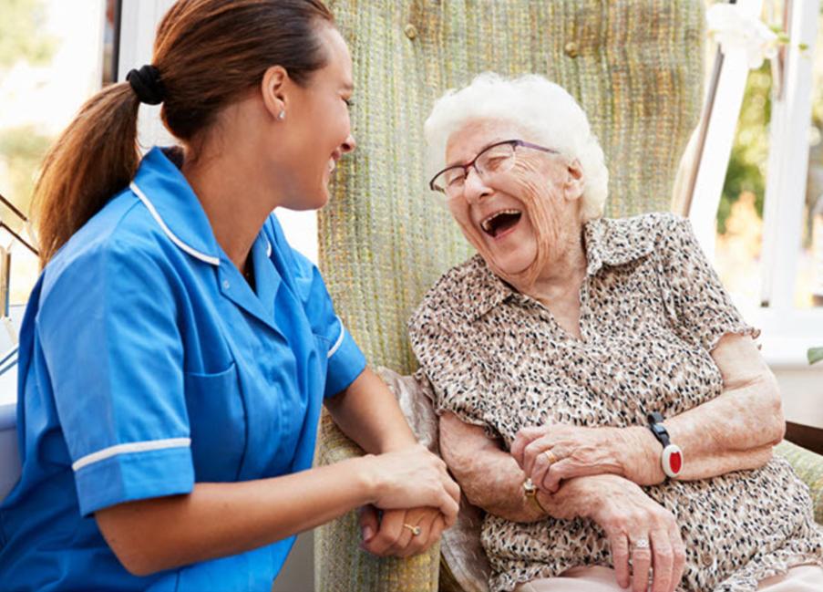 A resident laughing with a nurse