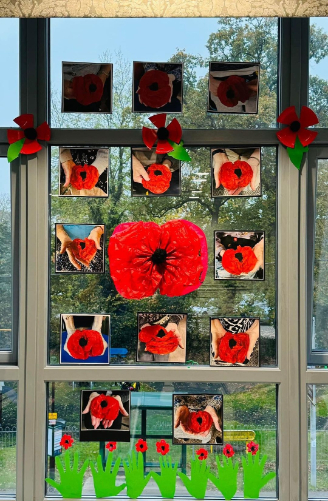 Handmade Remembrance Day display at Valerian Court Care Home, featuring tissue paper poppies, knitted freefalling poppies, and painted tributes including soldiers and planes.