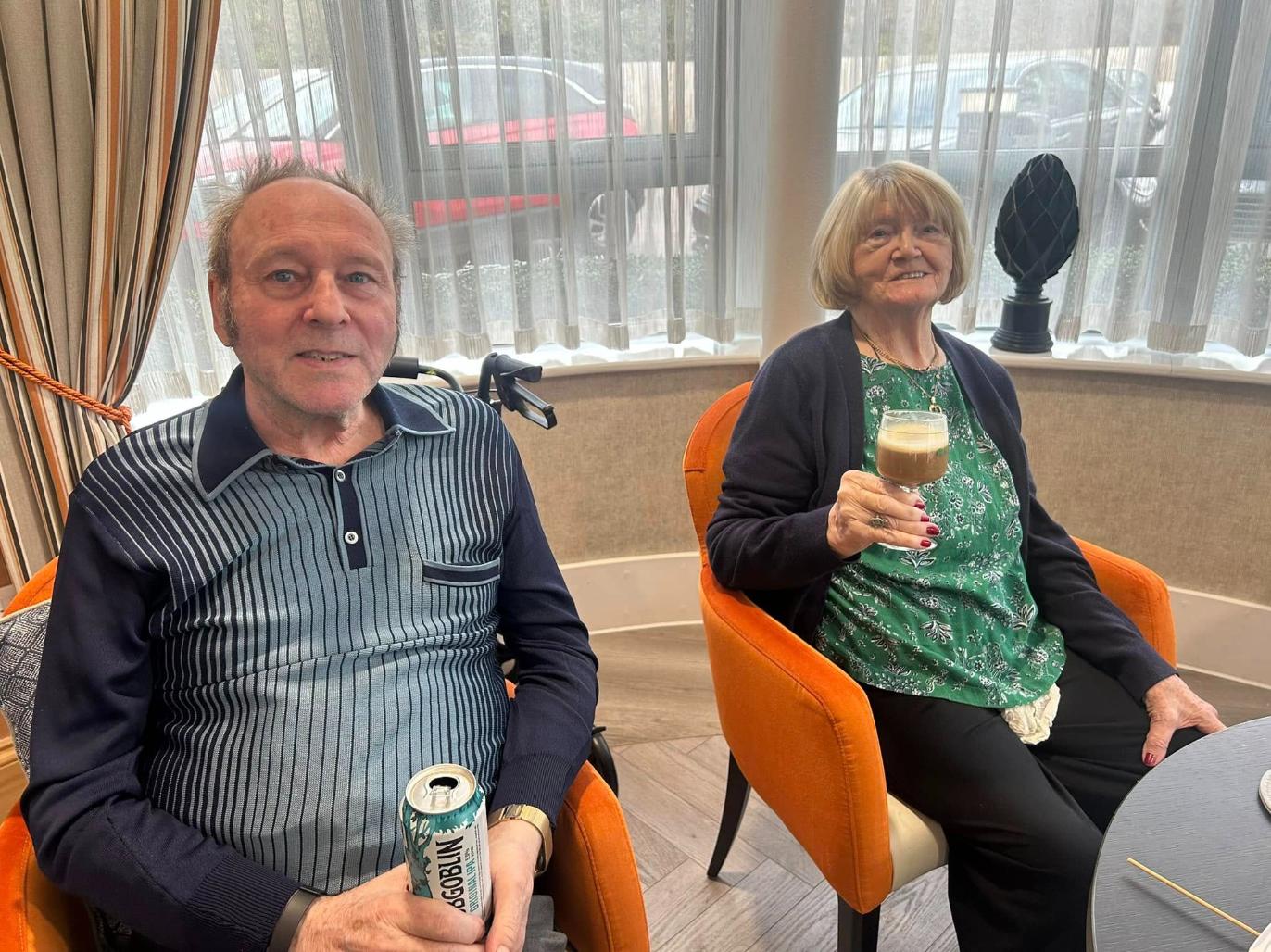 residents enjoying a drink sat in comfortable orange armchairs