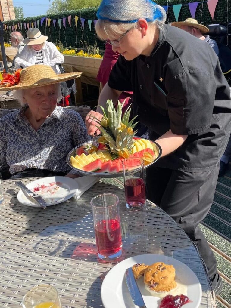 chef handing out fruit platter to residents