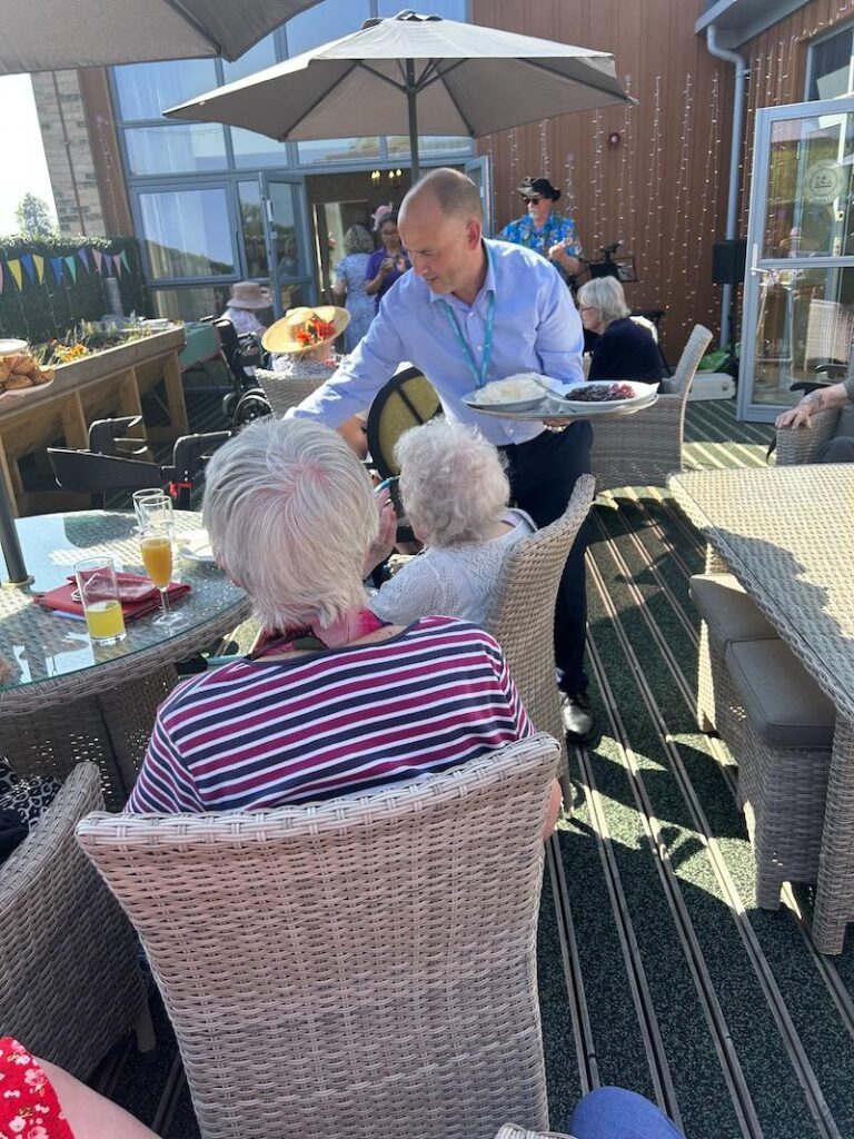 our home manager giving residents food to enjoy