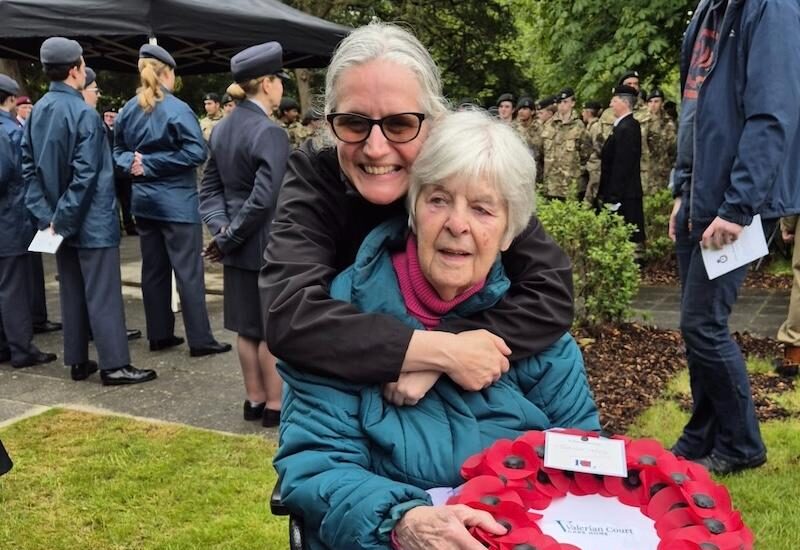 resident and carer with poppy wreath