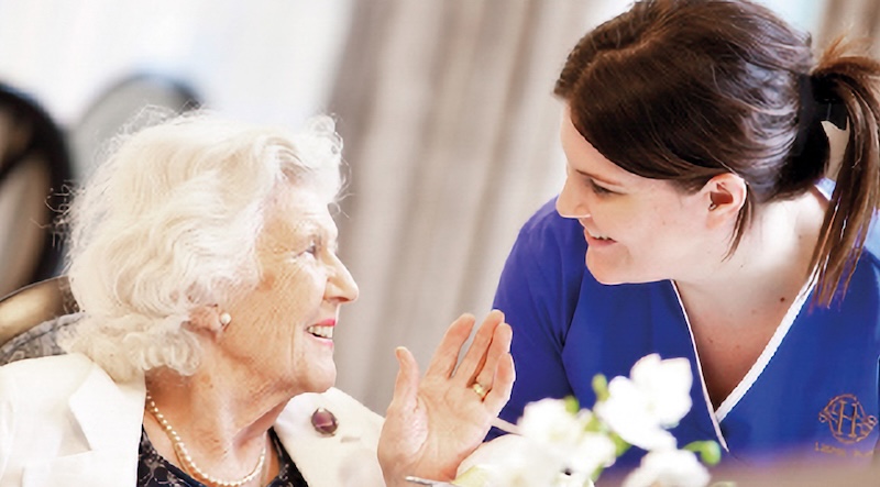 resident and carer looking at each other smiling