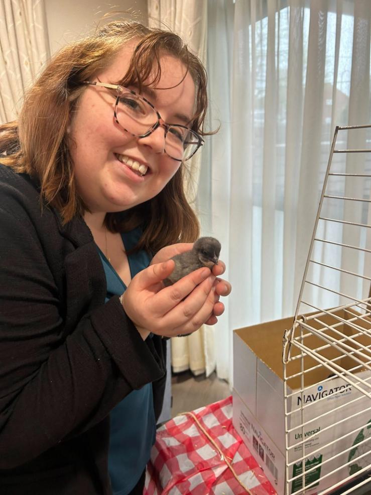 lady wearing glasses holding a chick