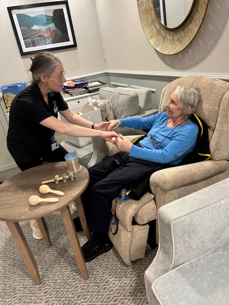 resident and carer holding hands and smiling at each other