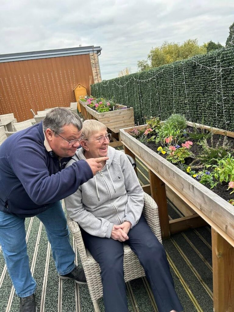 one of our residents sat in the garden with a loved one