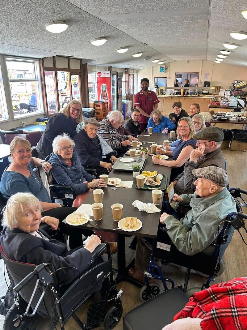 a group of our residents at the local cafe with hot drinks and a snack