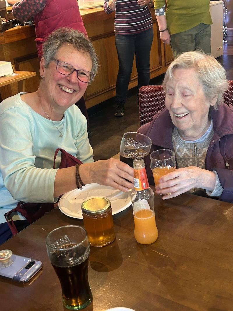 residents in the pub together smiling sharing a coke and J2O