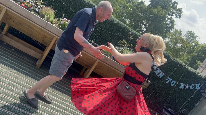 man and a woman dancing in a garden