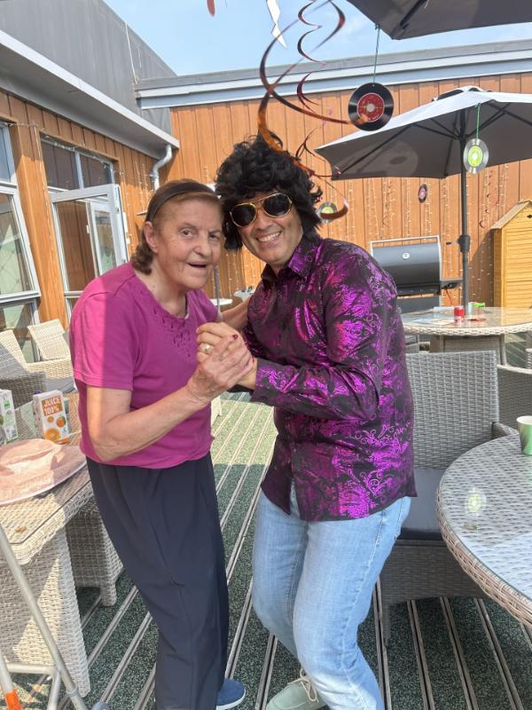 two people dancing and smiling in garden