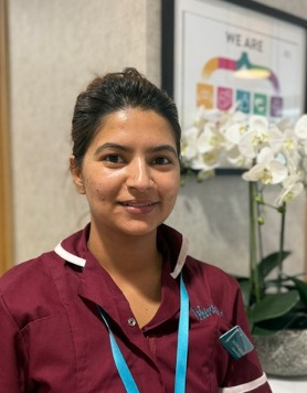 lady in a red care uniform posing for staff photo
