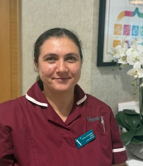lady in a red care uniform posing for staff photo