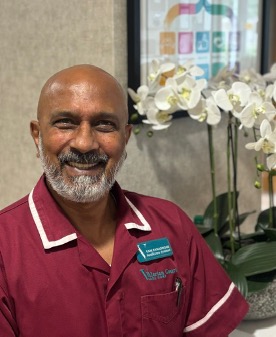 man in a red care uniform posing for staff photo