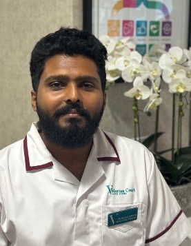 man in a white care uniform posing for staff photo