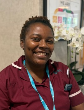 lady in a red care uniform posing for staff photo