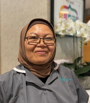 lady in a grey shirt taking a picture for staff page