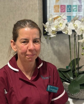 lady in a red care uniform posing for staff photo