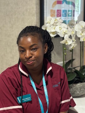 lady in a red care uniform posing for staff photo
