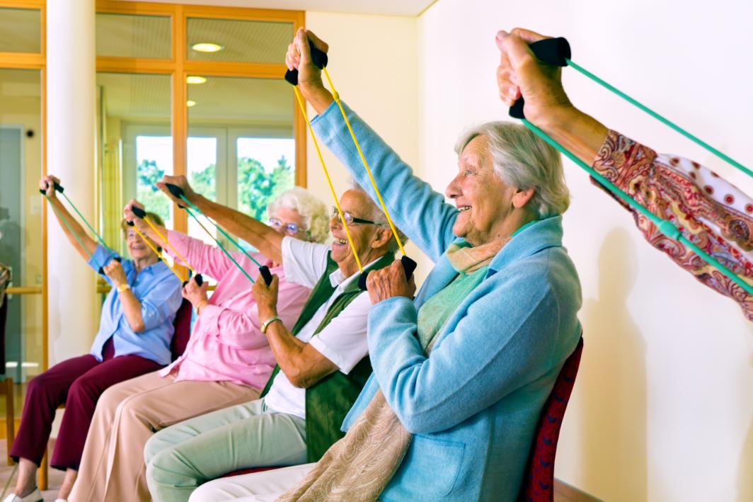 Women in chairs using stretching bands