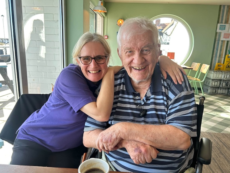 resident smiling with carer in restaurant